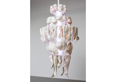 A sculpture that appears to be like a chandelier made of various plaster cast body parts.