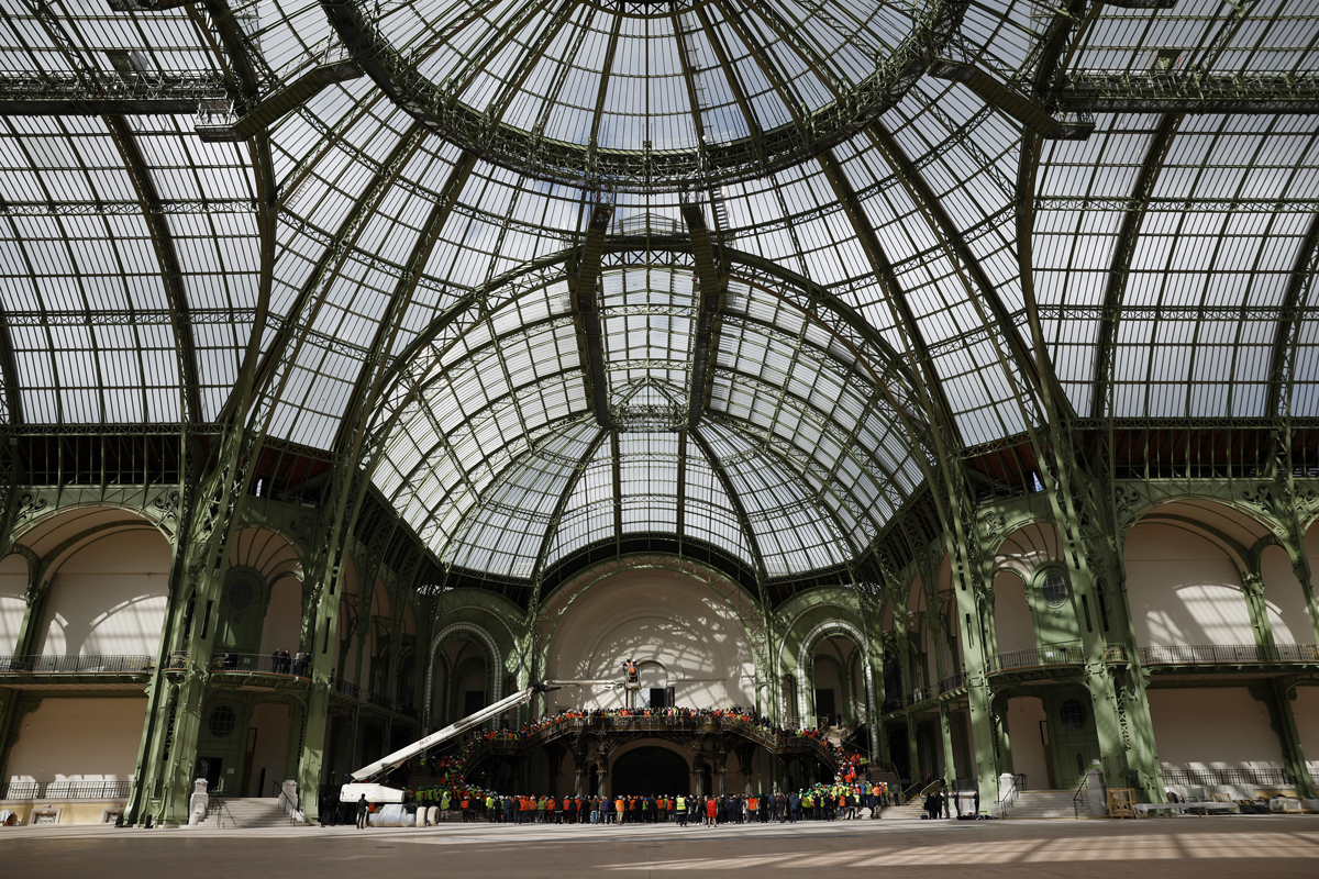 Employees in charge of the renovation work listen to French president giving a speech during his visit to Le Grand Palais, in Paris, on April 15, 2024, 100 days ahead of the Paris 2024 Olympic Games. Le Grand Palais will host the fencing and taekwondo competition events during the Paris 2024 Olympic Games. (Photo YOAN VALAT/POOL/AFP via Getty Images)