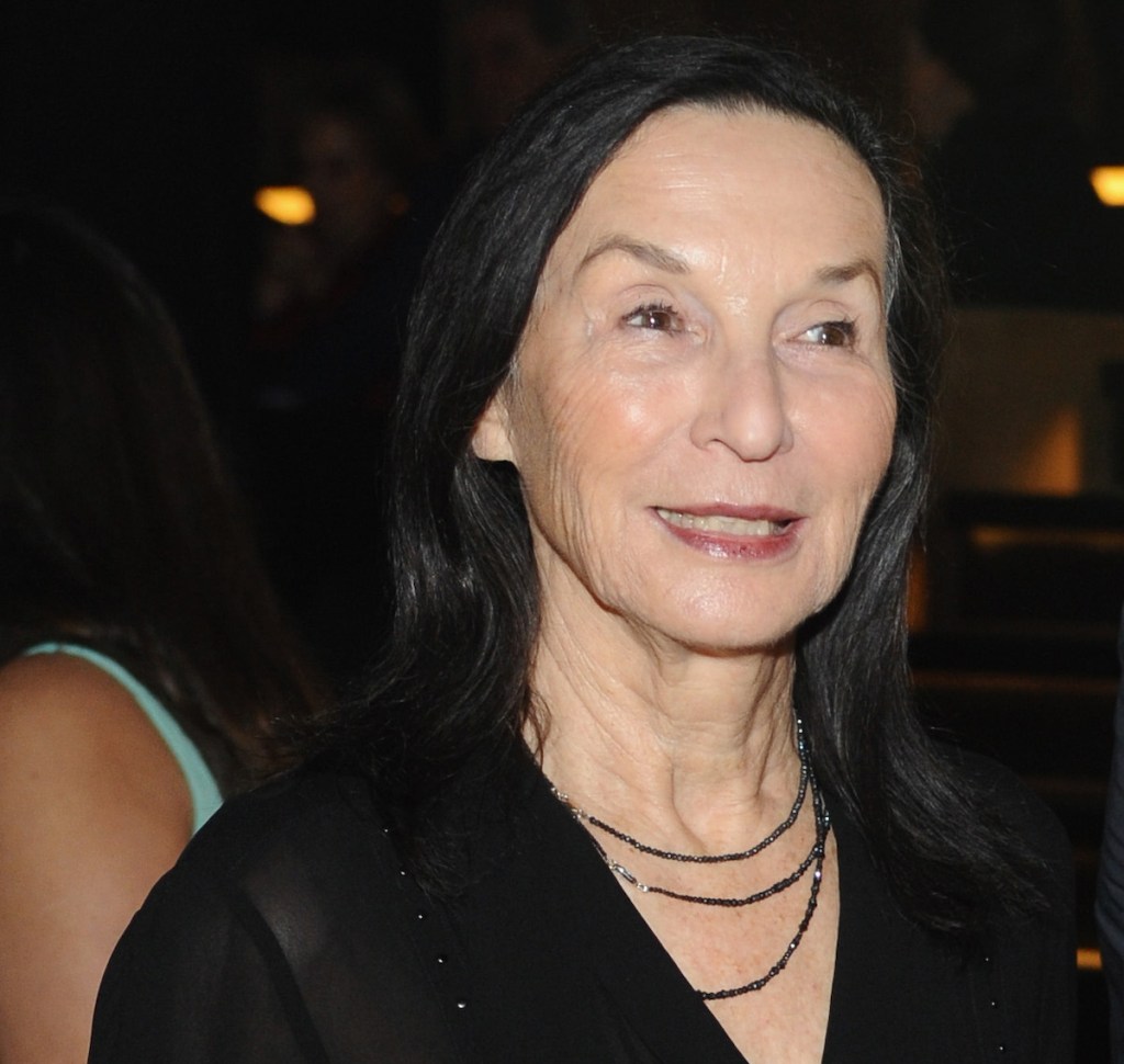 A white woman in a black dress at a party.