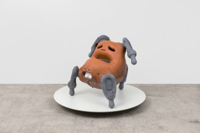 A sculpture resembling a potato with grey legs.