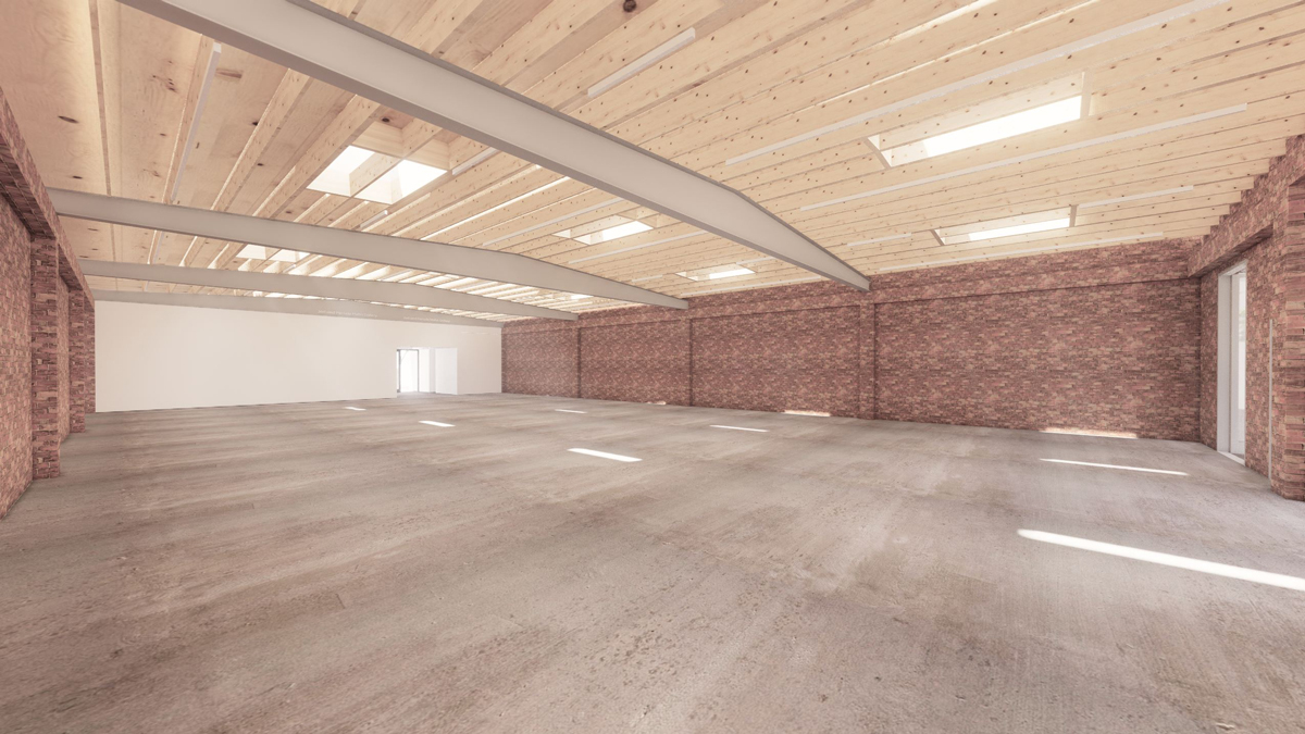 View of an exmpty gallery space with three walls of red brick, steel beams, concrete floors, and wood panels on the ceiling.